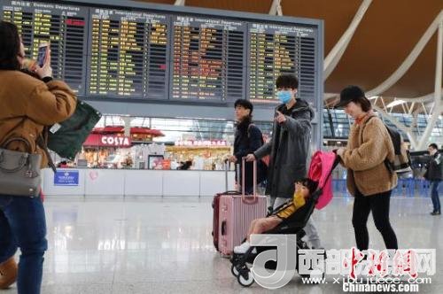 旅客帶著孩子前往辦票柜臺辦理登機手續(xù)。　殷立勤 攝