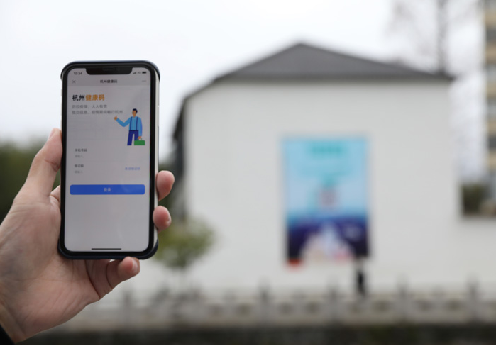 在浙江省杭州市臨安區(qū)天目山鎮(zhèn)，一名居民在“杭州健康碼”海報(bào)上掃碼申領(lǐng)個(gè)人二維碼。新華社發(fā)