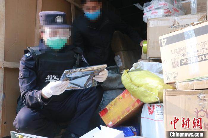 圖為勐康邊檢站民警在對(duì)快遞運(yùn)輸車輛進(jìn)行例行檢查?！钐?攝